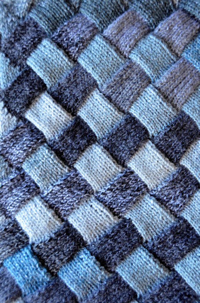 Closeup of light blue and gray entrelac Woven Sky Throw fabric.