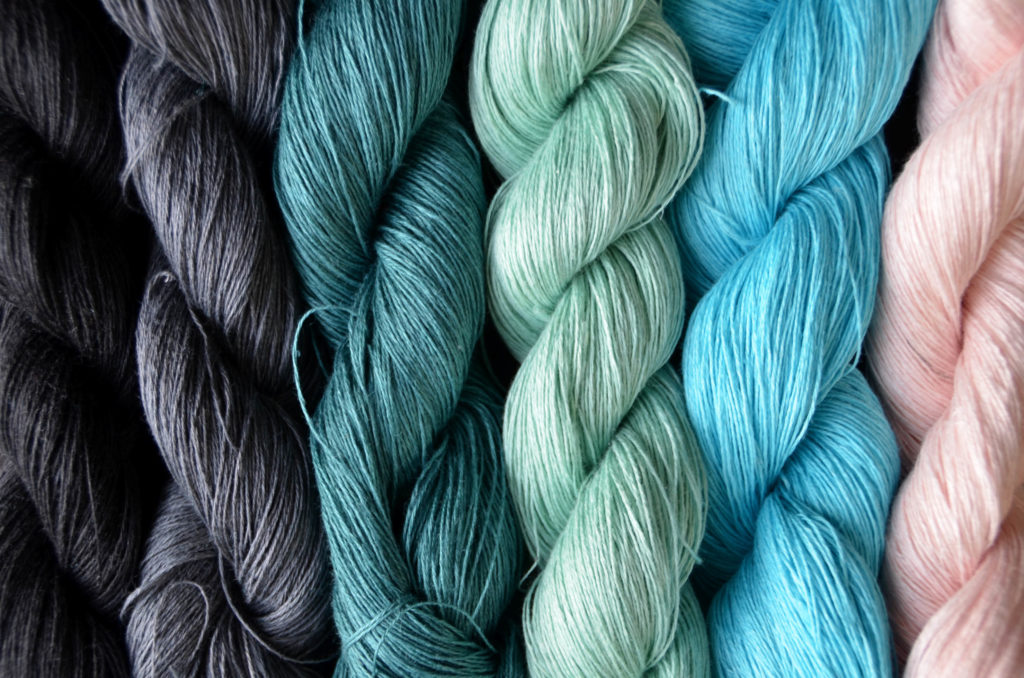 Image of six skeins of cool-toned Flax Lace yarn