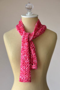 red lace cotton scarf tied at the neck on a dressform