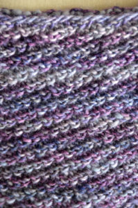 a closeup of a diagonally ribbed purple knitted fabric