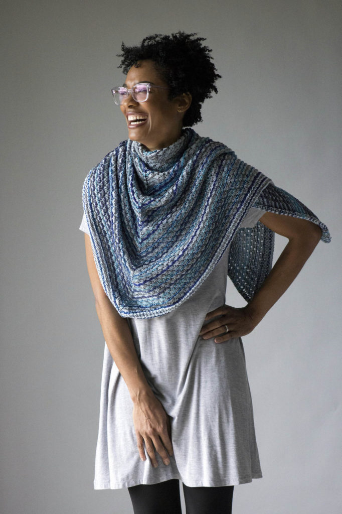 woman laughing wearing knitted blue shawl