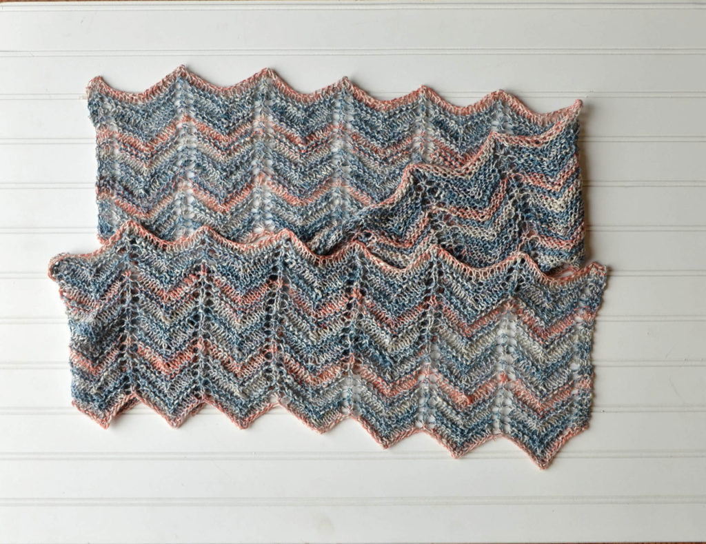 Knitted variegated scarf lying flat on white background