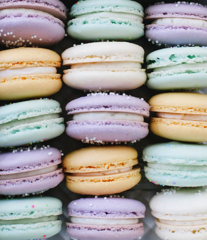Closeup photo of light purple, green, peach, and cream macarons