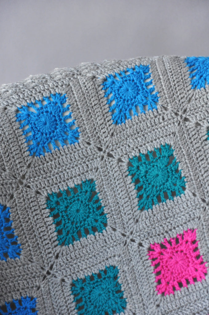 Blue, green, and pink granny squares in crochet Oasis Blanket