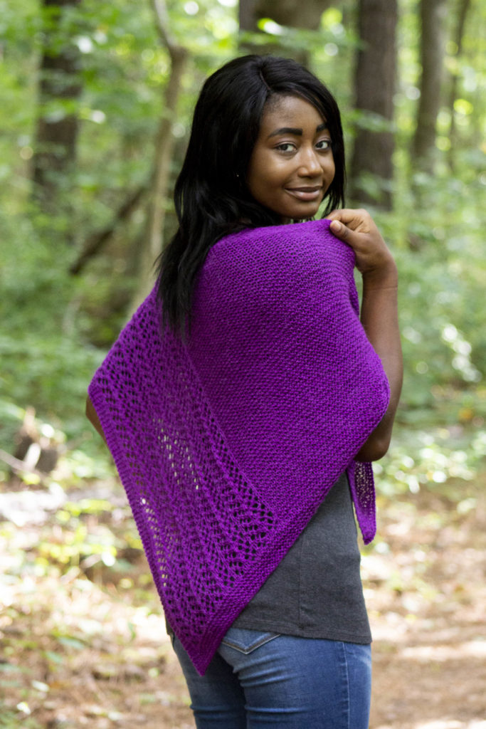 Woman looking over shoulder wearing purple knit lace shawl