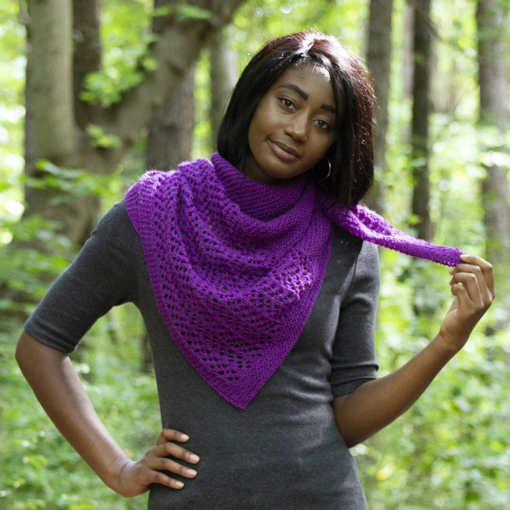 Young woman modeling knitted triangular purple shawl