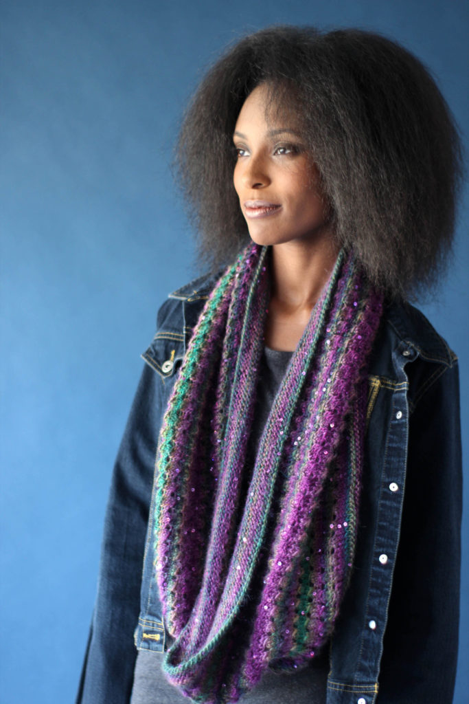 Woman wearing long knitted purple sequined cowl