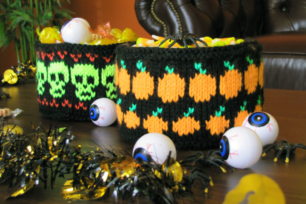 Photo of two knitted Halloween bowls filled with candy