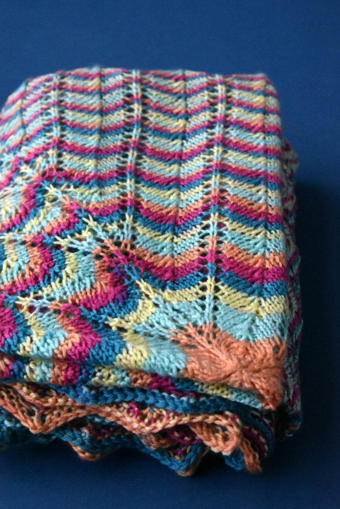 Image of folded tropical-colored afghan knit in Uptown DK Colors.