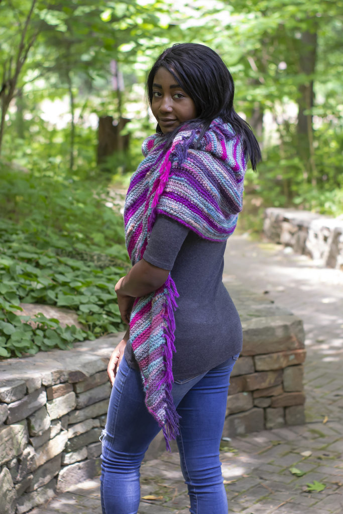 woman wearing colorful blue and fuchsia knit shawl
