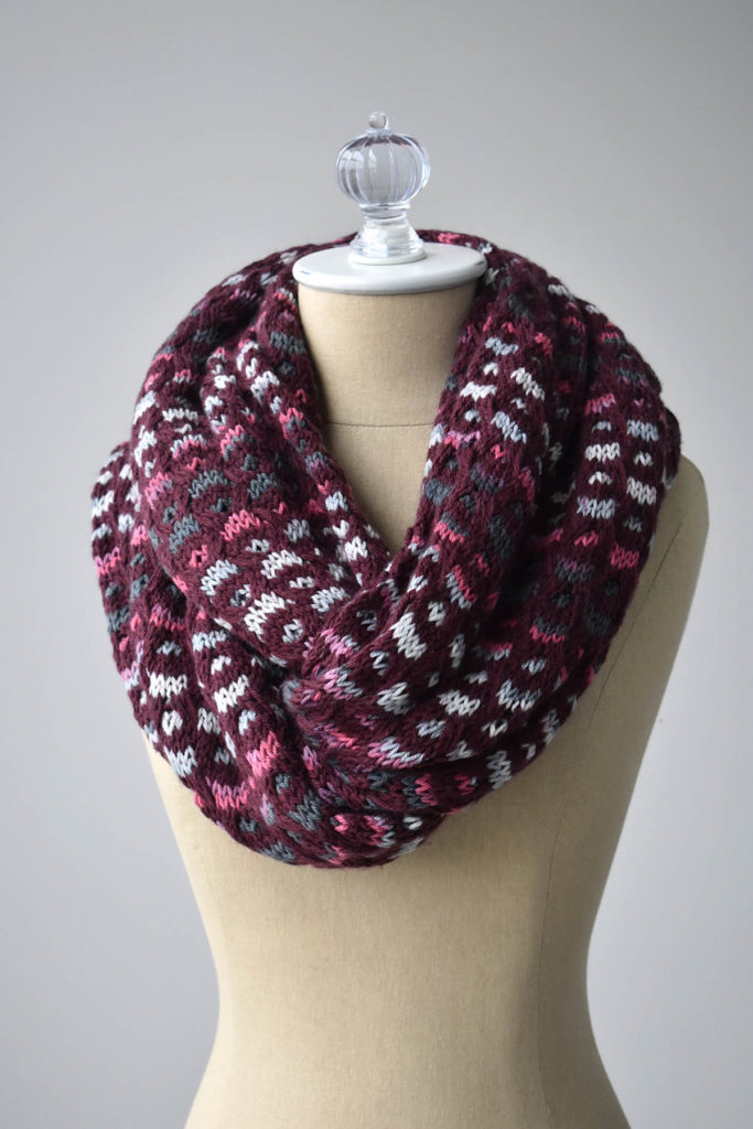 Image of dark red and striped knitted cowl on dressform