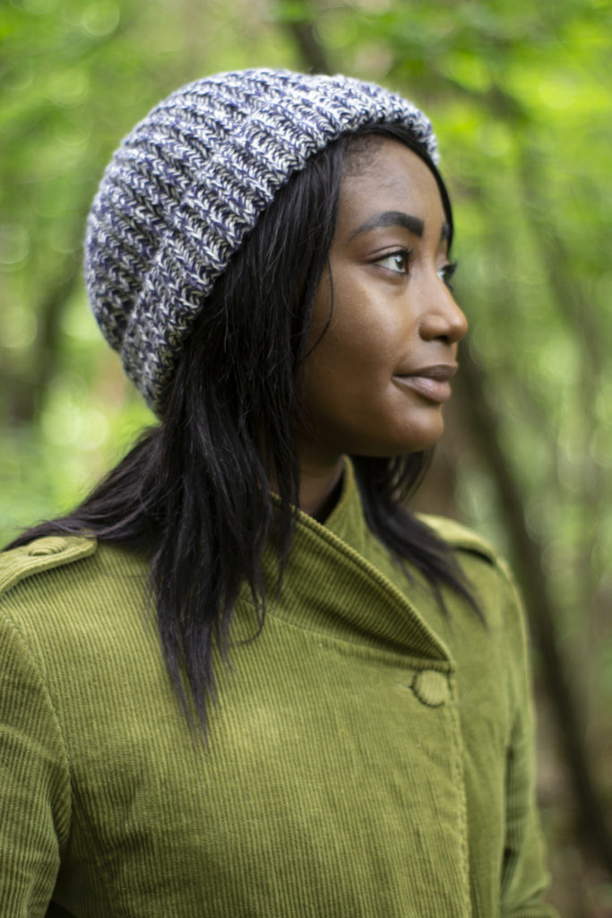 young woman wearing blue and gray cap knit in Bella Cash yarn