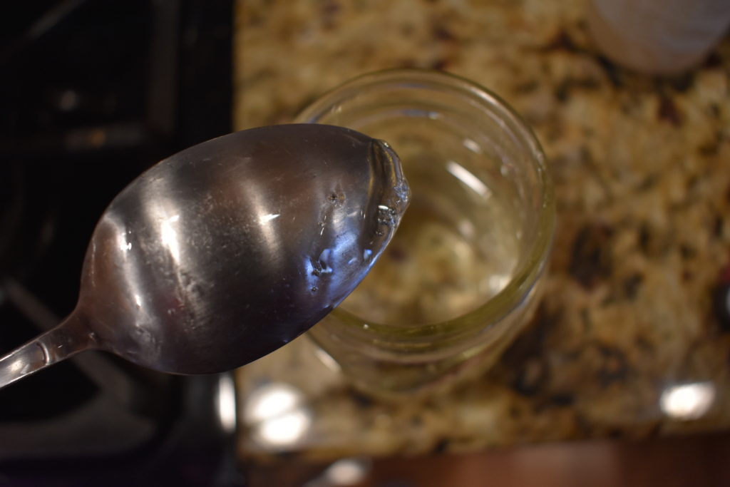A spoon with a mixture of water, sugar, salt, and corn syrup. 