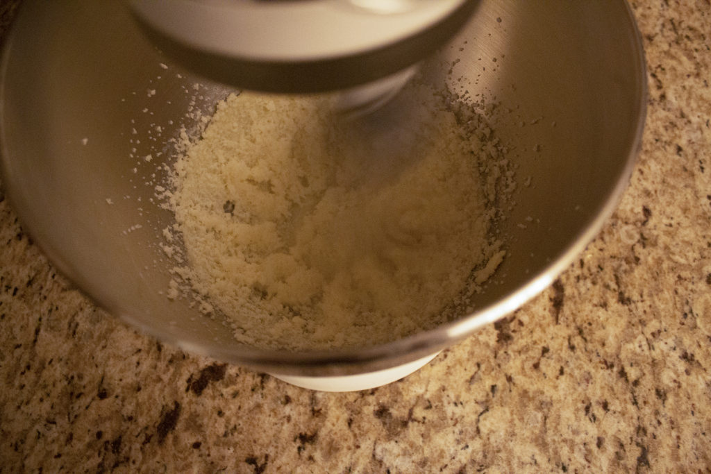 A bowl of butter and sugar being beaten together.