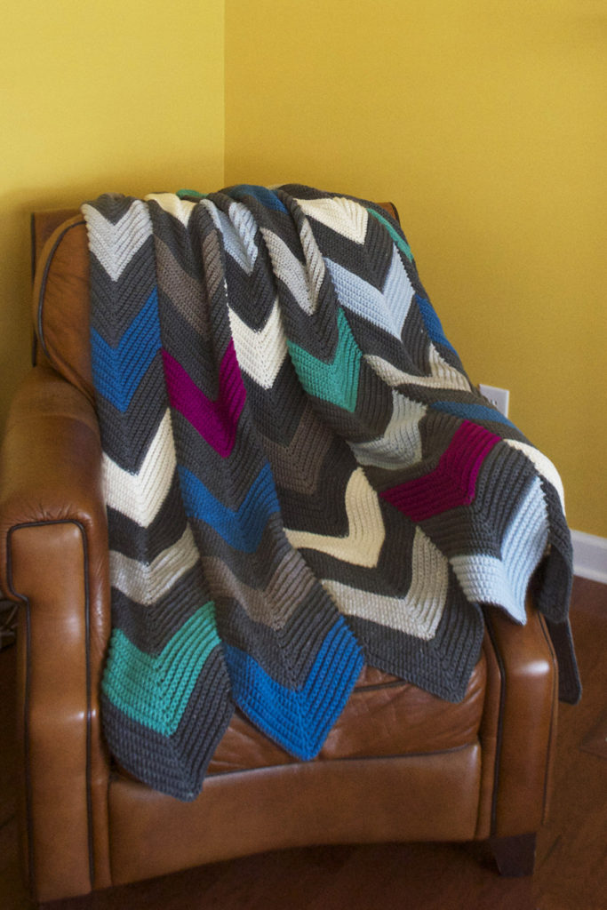 A crochet blanket in blues and grays
