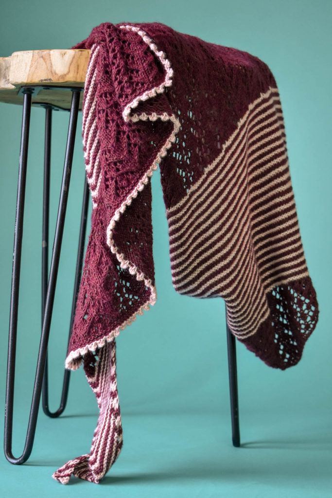 A shawl draped over a wood side table. 