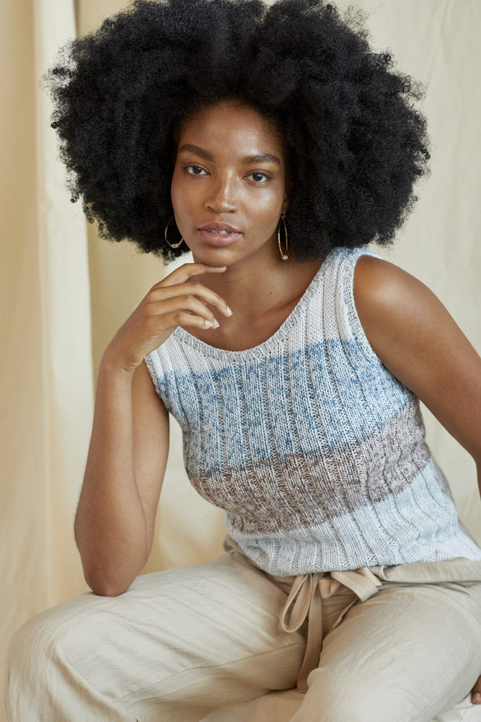 Seated woman wearing ribbed knitted cotton tank top