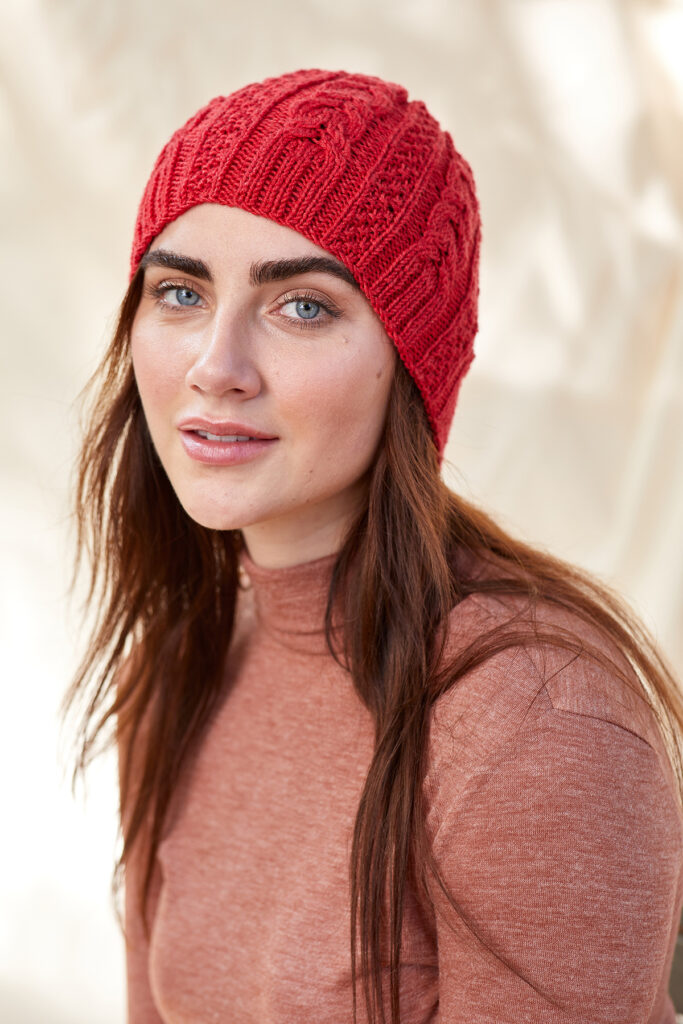 woman wearing cabled hat knit in Wool Pop