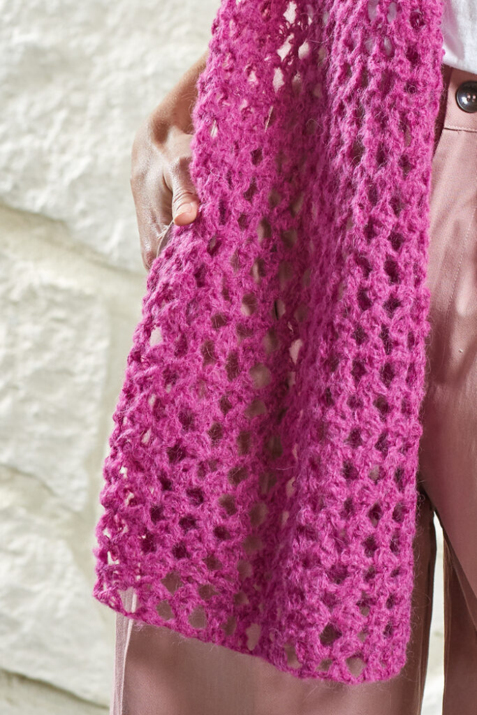 Closeup of stitch pattern in pink crocheted shawl
