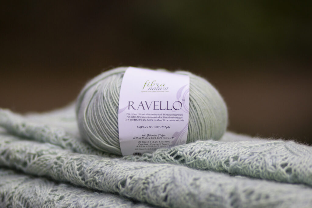 Light green ball of Ravello yarn sitting on knitted lace