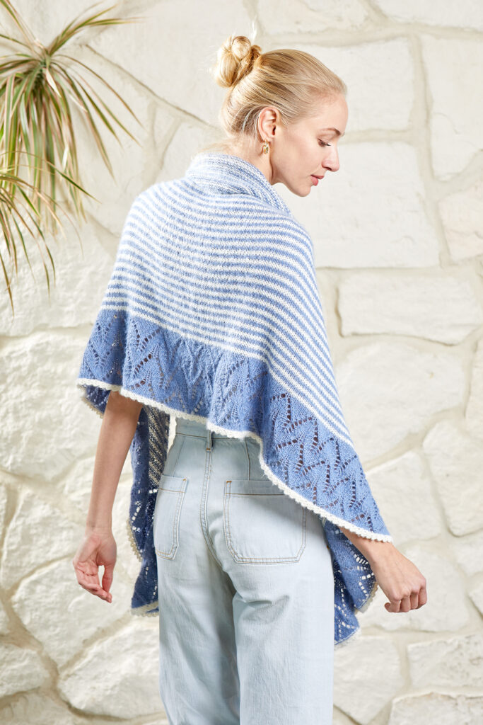 Rear view of woman wearing blue and white shawl knitted in Nymph