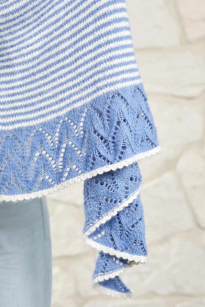 Detail of lace edge of blue and white knitted striped shawl 