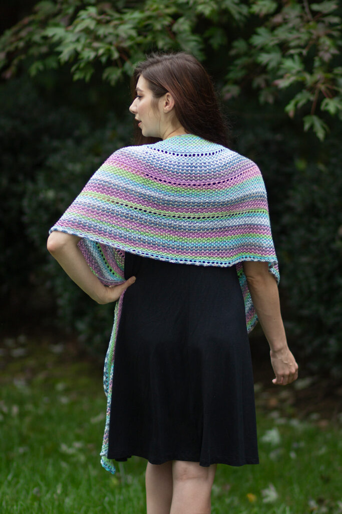 Woman wearing knitted shawl and facing away from viewer