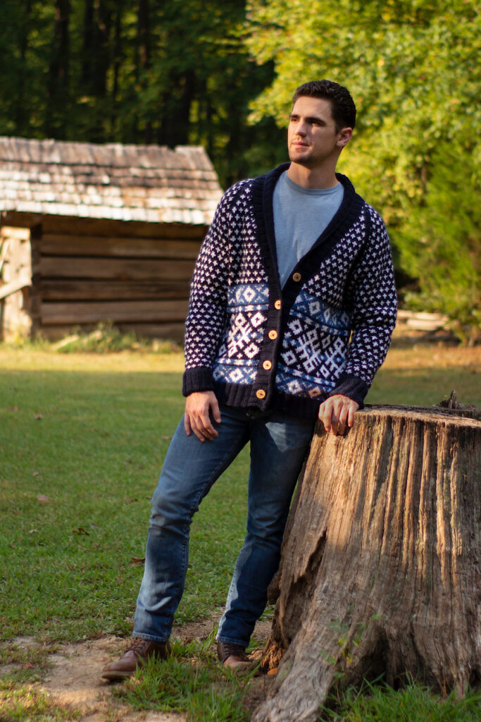 Man wearing patterned cardigan standing in field
