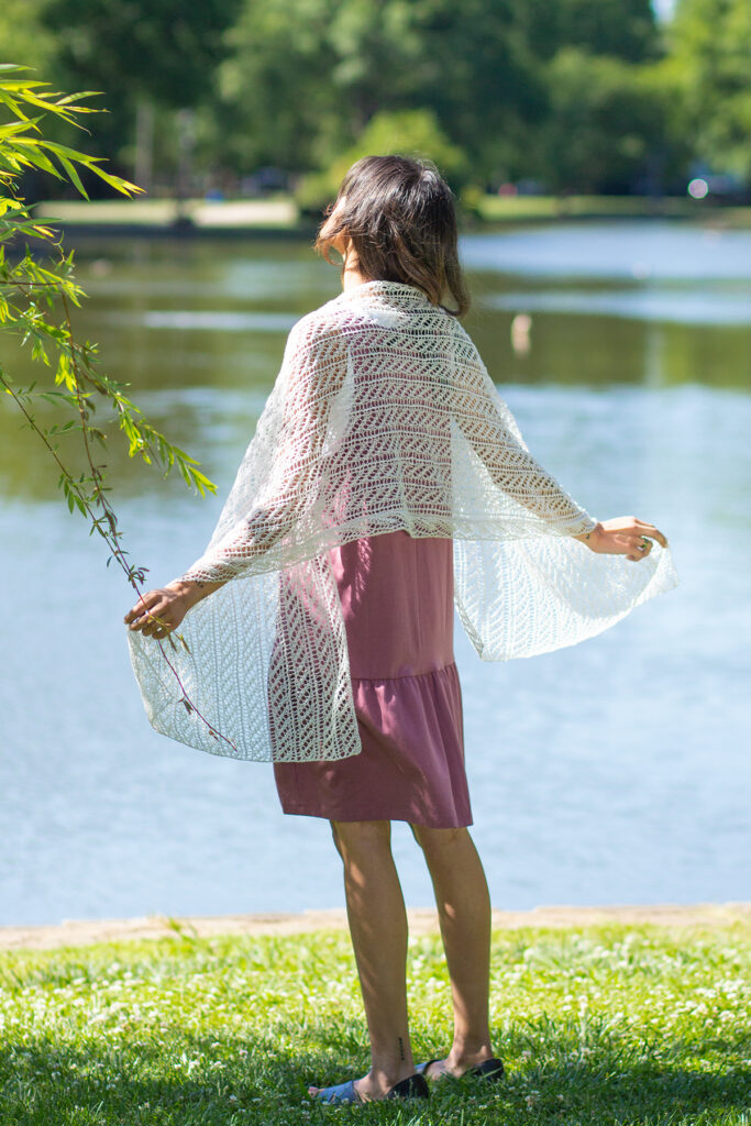 Rear view of woman outdoors wearing silvery lace wrap knitted in Flax yarn