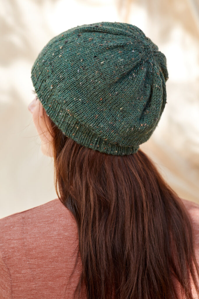 Rear view of woman wearing forest green knitted hat
