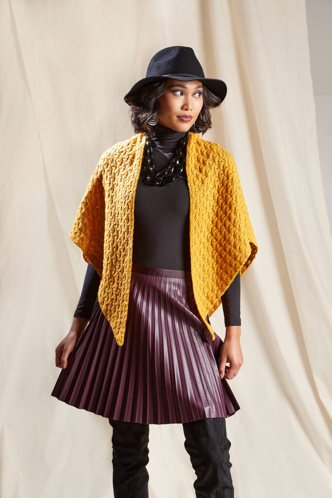 woman wearing gold triangular shawl crocheted in Ravello yarn