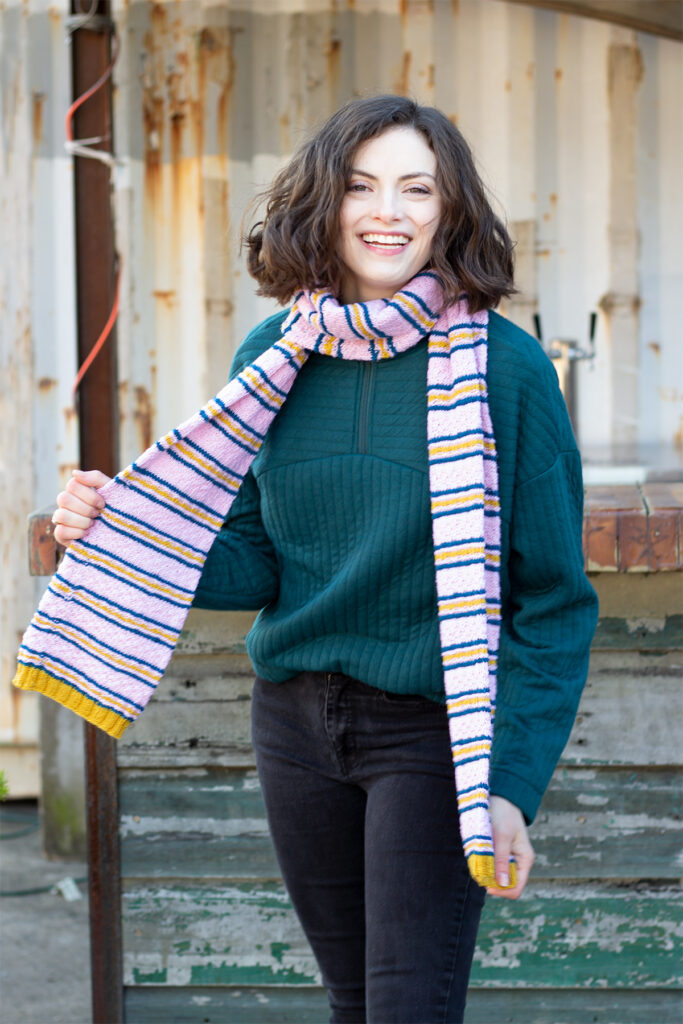 Young woman wearing knitted striped scarf
