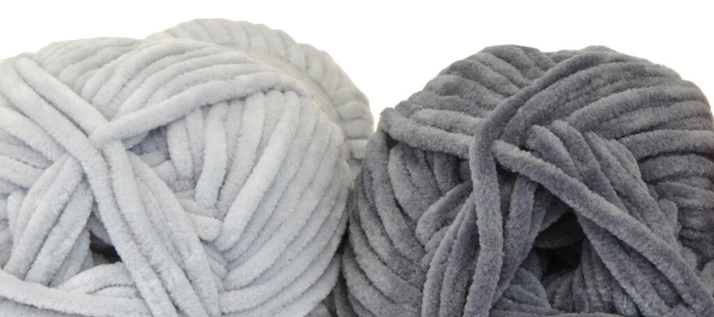One light gray and one darker gray skein of Bella Chenille yarn.
