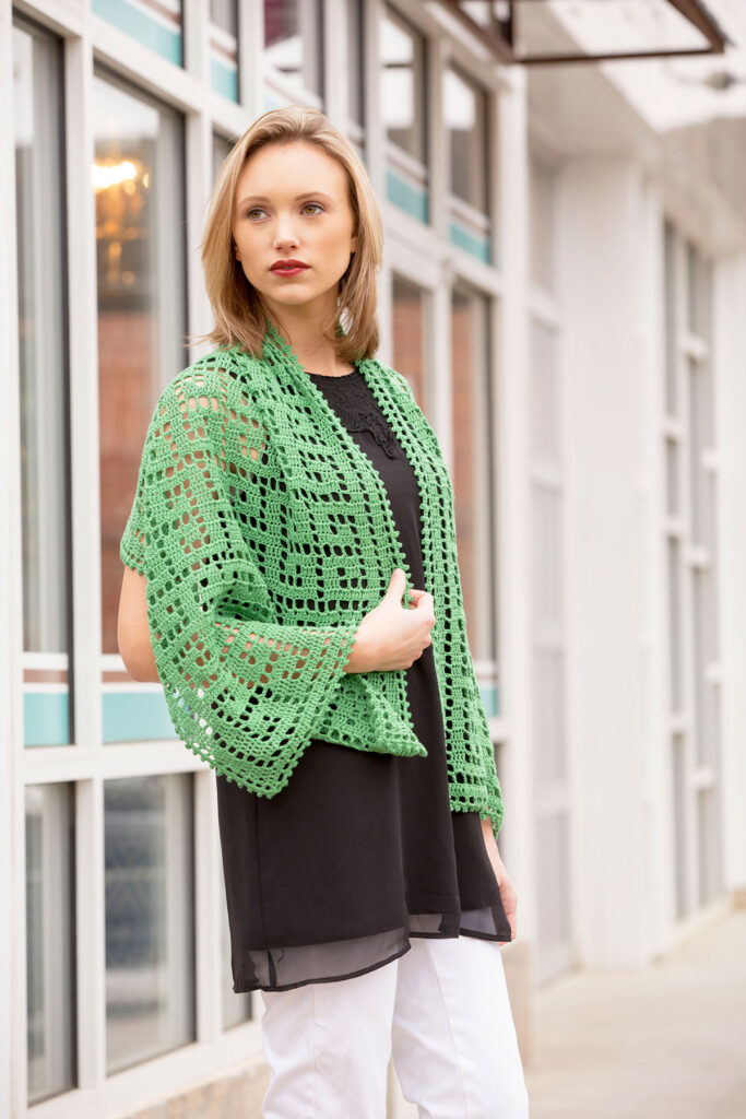 Woman with light green filet crochet shawl draped over her shoulders