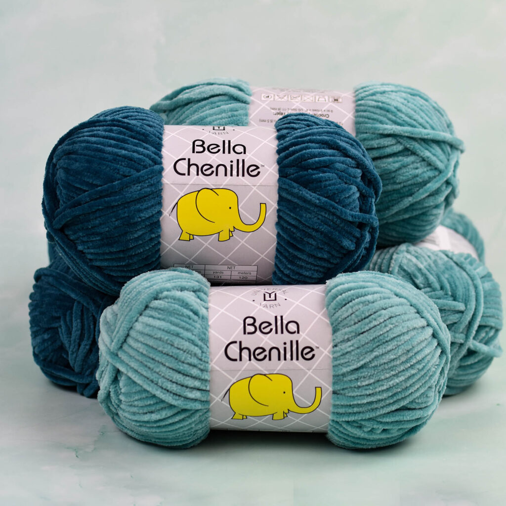 Skeins of aqua-toned Bella Chenille yarn stacked on top of one another.