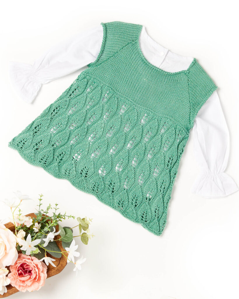 Light green sleeveless children's dress with lace skirt