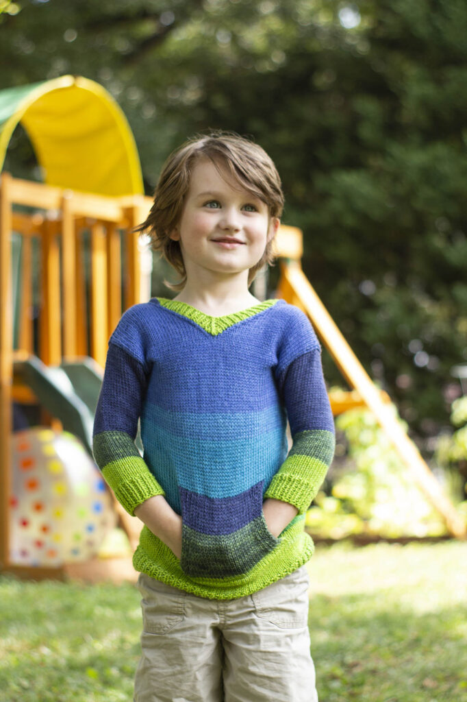 Boy wearing striped knitted hoodie pullover with pockets
