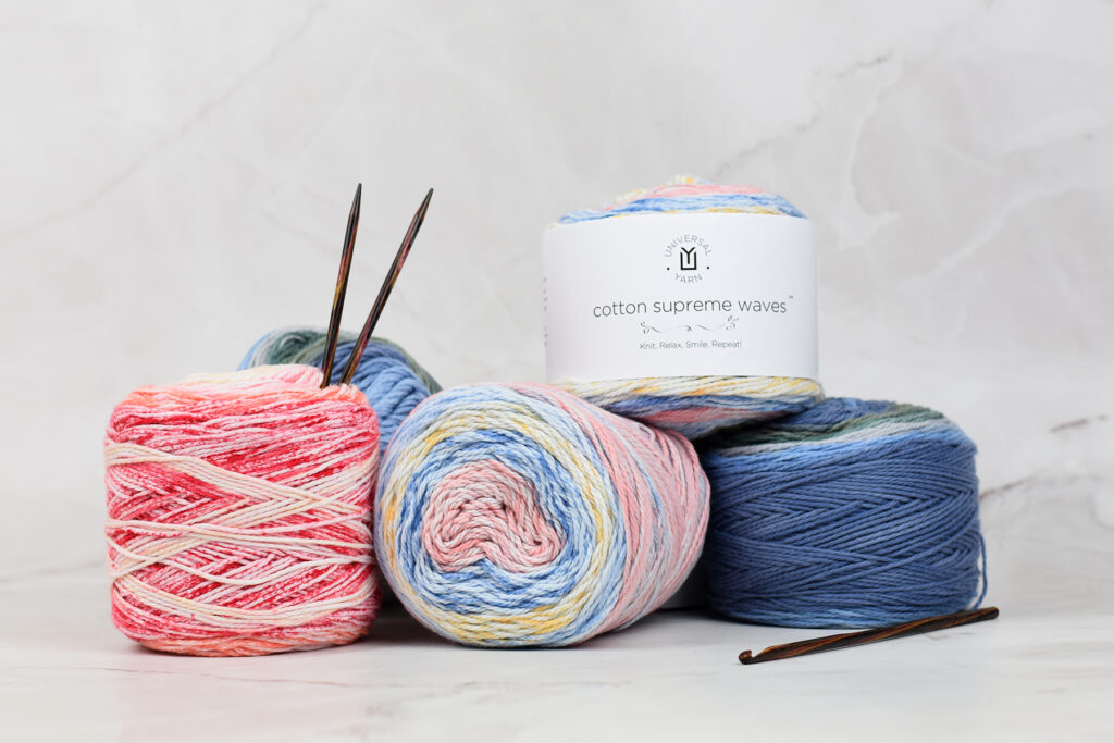 Image of skeins of Cotton Supreme Waves yarn with knitting needles and crochet hook