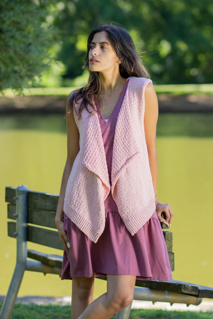 Woman wearing pink vest knitted in Papyrus yarn