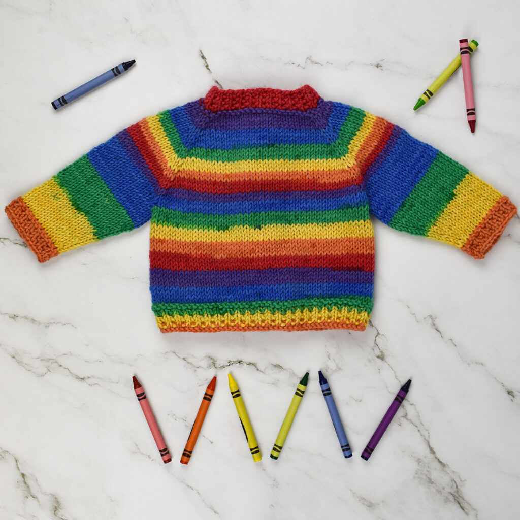 Rear view of Art Class Cardigan toddler sweater knitted in Deluxe Stripes.