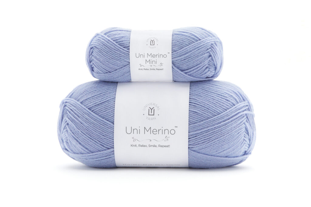 A photo of two skeins of yarn, both Universal Yarn Uni Merino. On the bottom is a 100-gram skein, and on top of it is a 25-gram mini skein. 