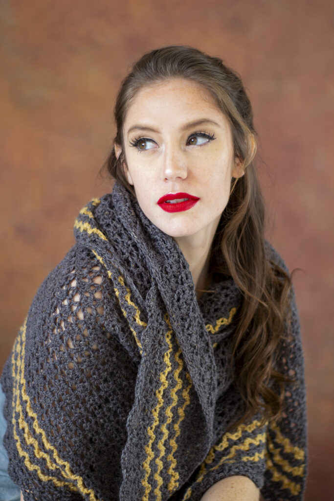 Seated woman wearing Branscombe shawl crocheted in Kingston Tweed