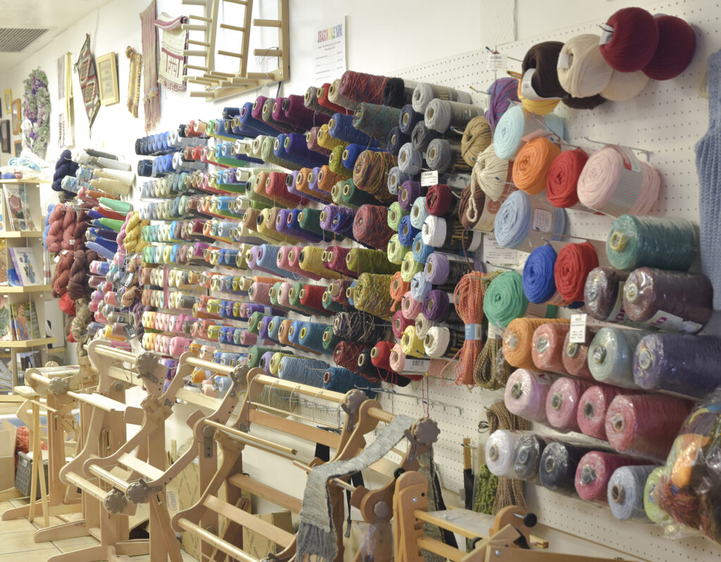 Picture of the weaving yarns on the wall that are available at Grandma's Spinning Wheel