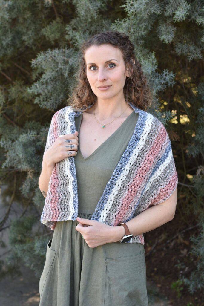 Photo of a person wearing the Foxglove wrap crocheted with our self-striping Offbeat yarn.
