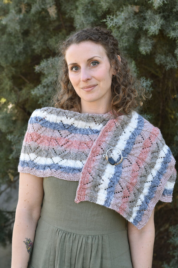Photo of a person wearing the Snapdragon wrap, knit with our Offbeat yarn.