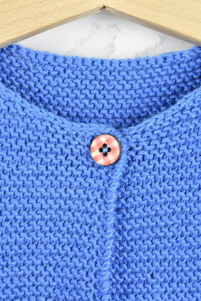 Close-up photo of the Cloudborn Cardigan showing the button on the neckline