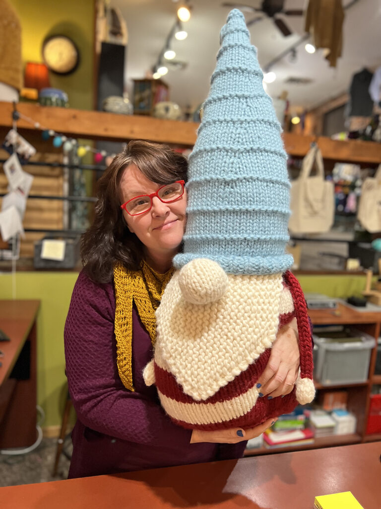 Photo of a giant stuffed gnome being held by a person