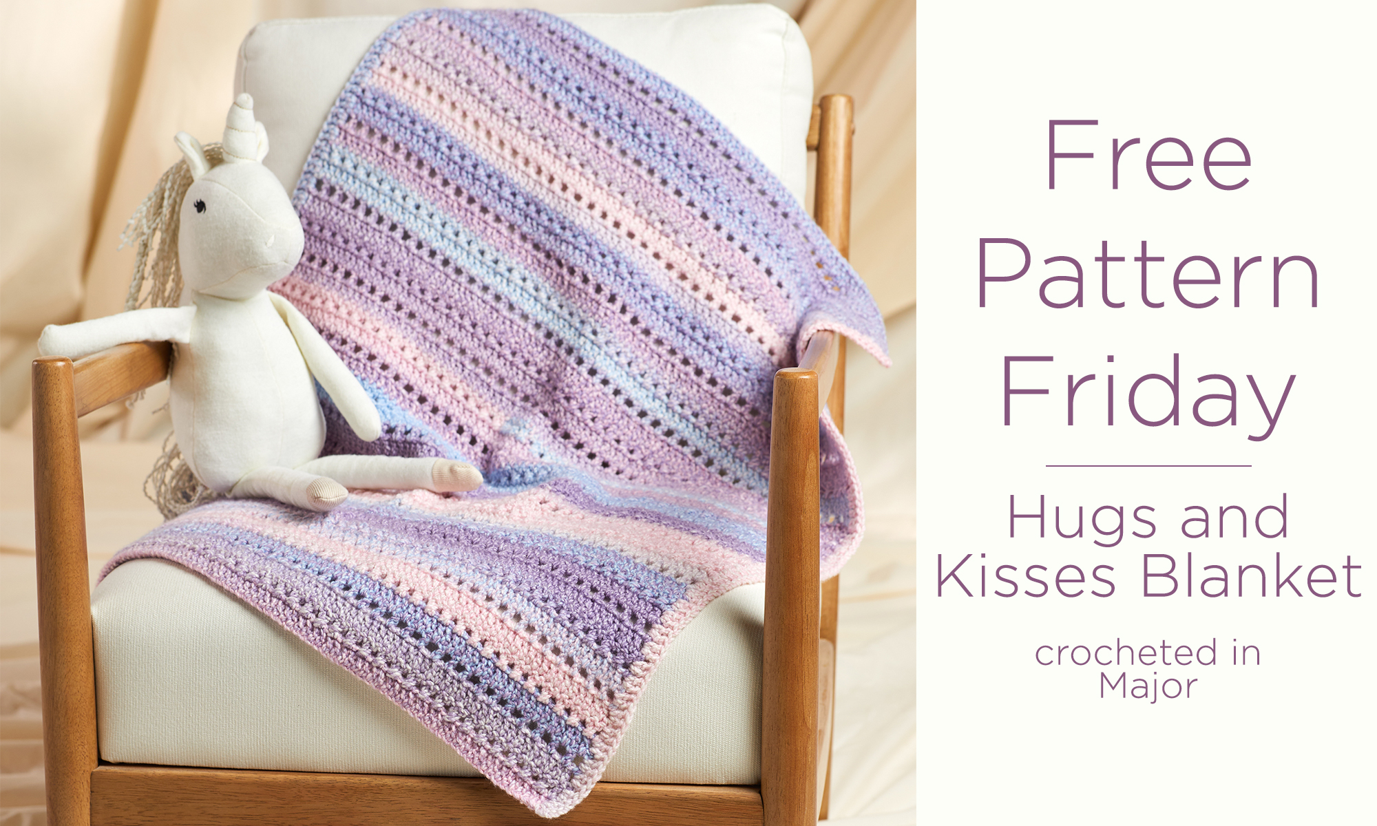 A crocheted blanket is draped on a chair with a stuffed unicorn sitting on top. Text reads "Free Pattern Friday. Hugs and Kisses Blanket, crocheted in Major."